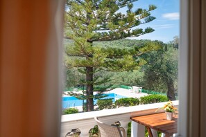 A balcony with a view of a pool and surrounding greenery. - Frangiskos Ena: Private Apt, shared pool. WiFi, A/C, close to the sea. (Saint Spyridon)