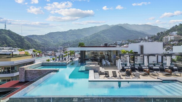 Piscina no terraço com vista clara das montanhas e do horizonte urbano.