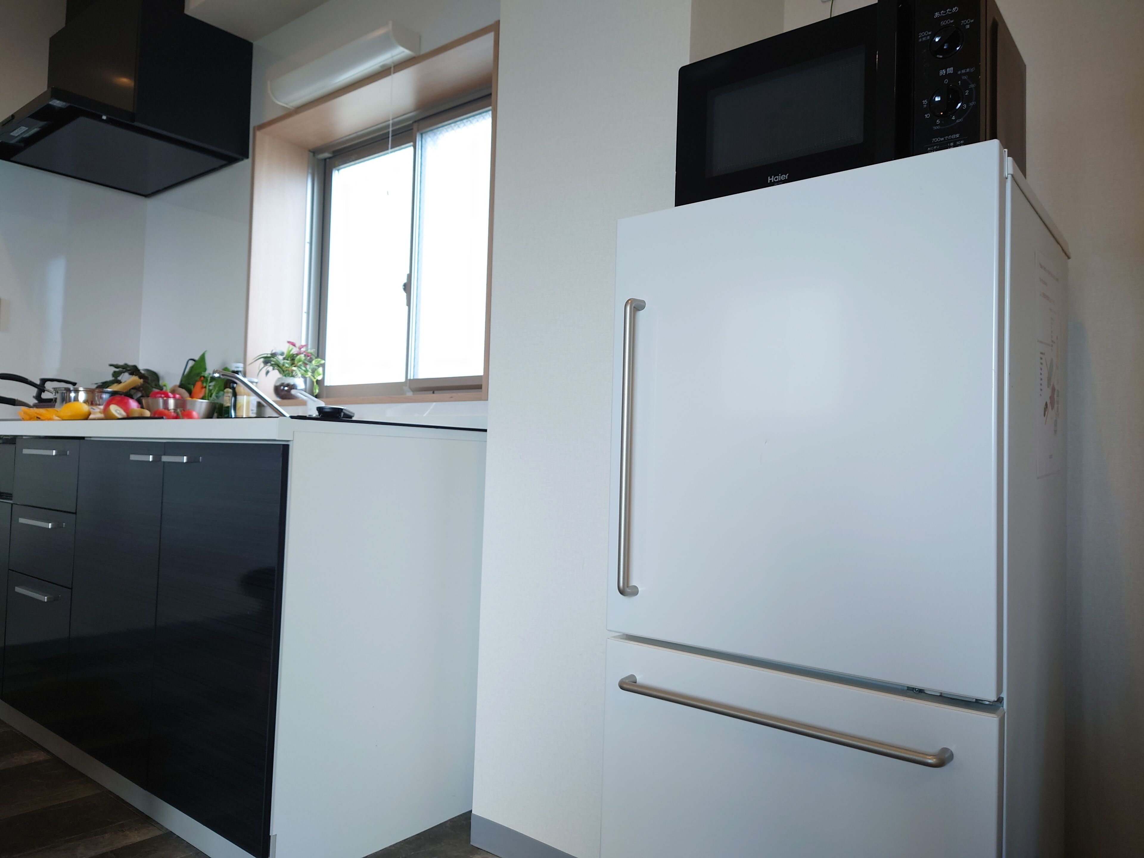 A kitchen with a white refrigerator, a black microwave, and a dishwasher.