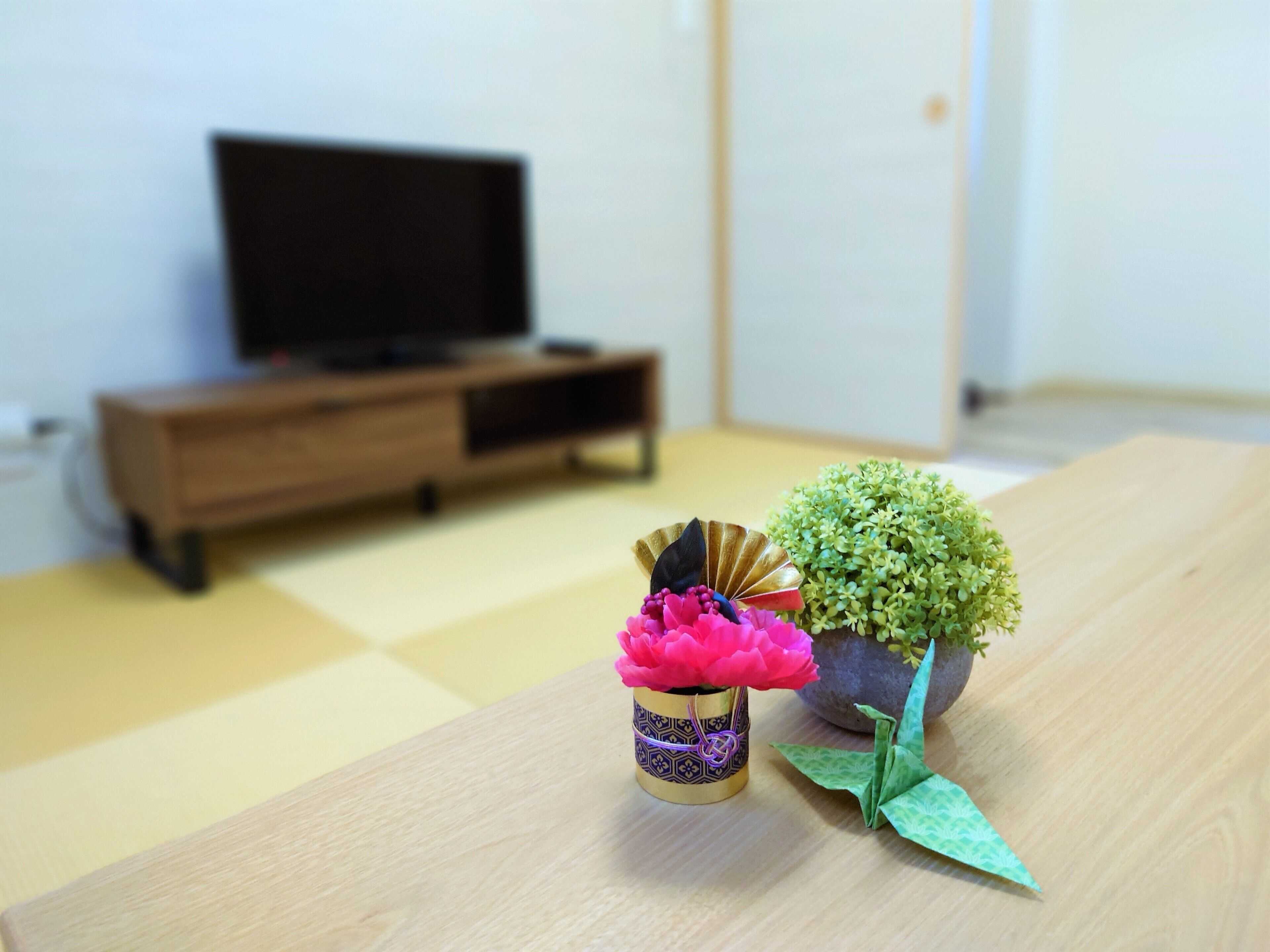A wooden table with a small potted plant and a decorative item.