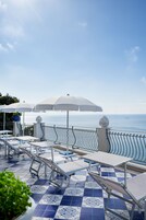 Una piscina al aire libre, sillones reclinables de piscina