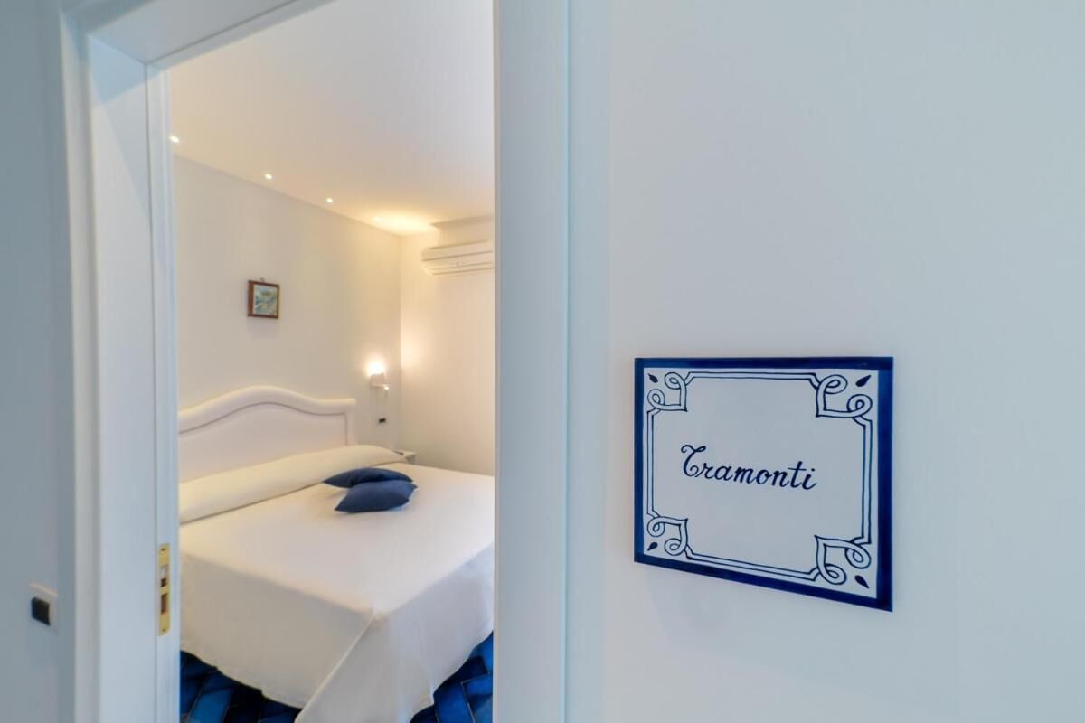 Un dormitorio con una cama, un cartel en la pared y una puerta que da a otra habitación.