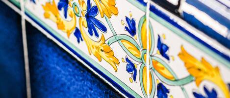 A close-up of a tiled wall with a floral pattern.