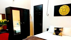 Een slaapkamer met een bed, een rode stoel, een kledingkast en een wanddecoratie.