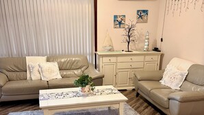 A living room with two sofas, a coffee table, a rug, and a staircase. - Sharpie’s Family Shack 🏝 Greenhead.   ☀️ Free Wi-Fi (Green Head)