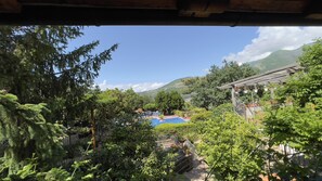 Una piscina envoltada de vegetació exuberant i un paisatge de muntanyes.