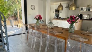 A modern kitchen with a dining area, clear chairs, woven placemats, and decorative vases. - South Corsica, Villa 14 p, swimming pool, beach at 300m (Sainte-Lucie de Porto-Vecchio)