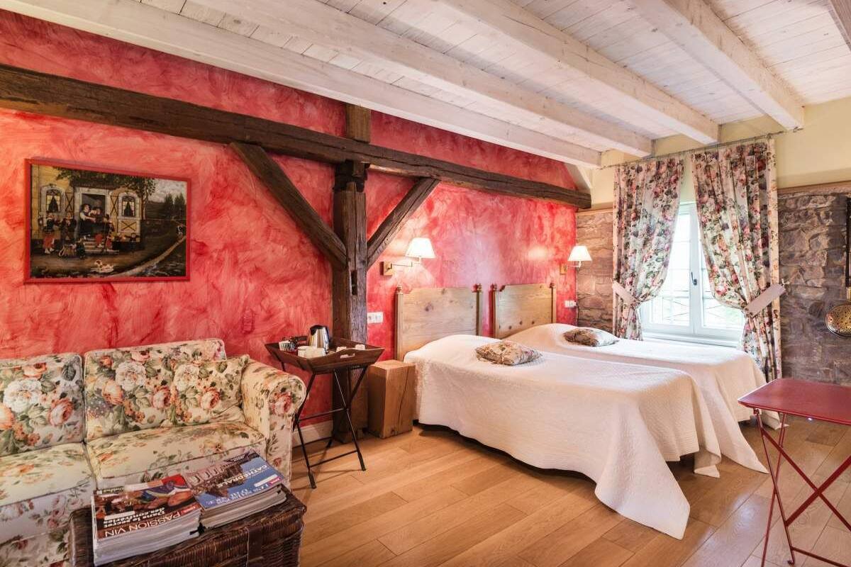 Une pièce avec un plafond en bois, un lit, un canapé et une table.