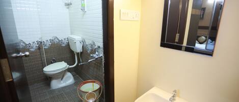 A bathroom with a toilet, sink, and a mirror.