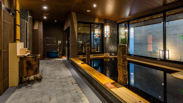 A modern interior with a wooden ceiling, a long bench, and a view through large windows. - Onyado Nono Asakusa Natural Hot Springs (Tokyo)