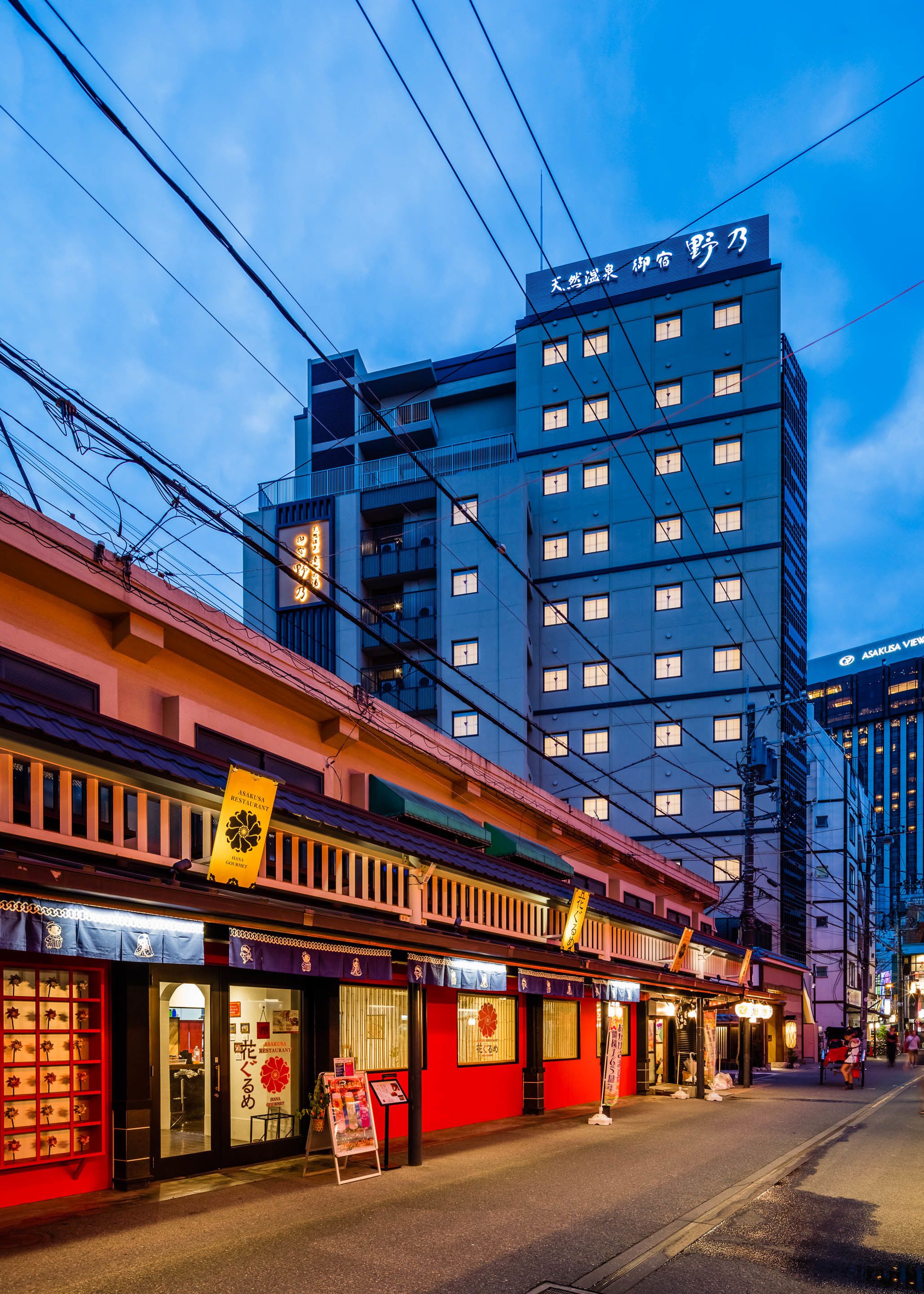 A multi-story building with a modern architectural design, featuring a prominent sign at the top.