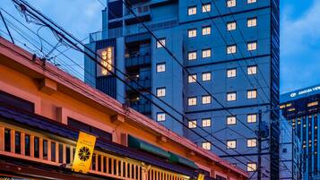 Un edificio de varios pisos con un diseño arquitectónico moderno, que presenta un letrero llamativo en la parte superior.