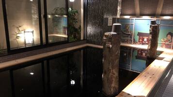 Un interior moderno con una piscina reflectante, bancos de madera y elementos decorativos.