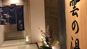 A traditional Japanese interior with tatami flooring, a wooden reception desk, and a sign with Japanese characters. - Onyado Nono Asakusa Natural Hot Springs (Tokyo)