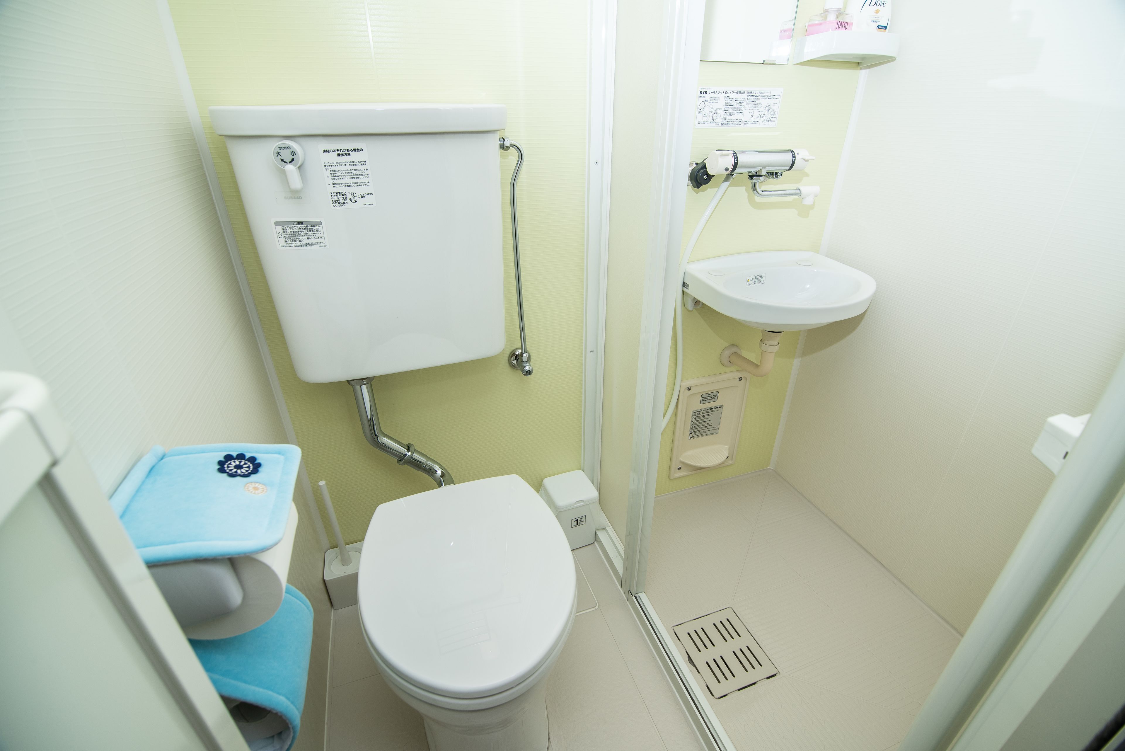 A small, compact bathroom with a toilet, sink, and shower.