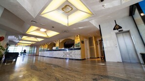 A spacious lobby with a marble reception desk, geometric ceiling lights, and a modern design. - Hotel Diplomat Palace (Rimini)
