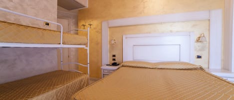 A room with bunk beds, a bedside table, and a nightstand.