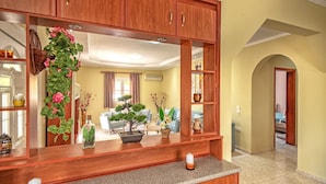 A kitchen with wooden cabinets, granite countertops, and various kitchen items. - Villa Eleon with private pool, BBQ and beautiful garden. (Zakynthos)