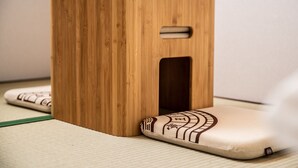 A wooden stool with a cut-out handle and a cushion with a geometric pattern. - Kujira 202 (Osaka)