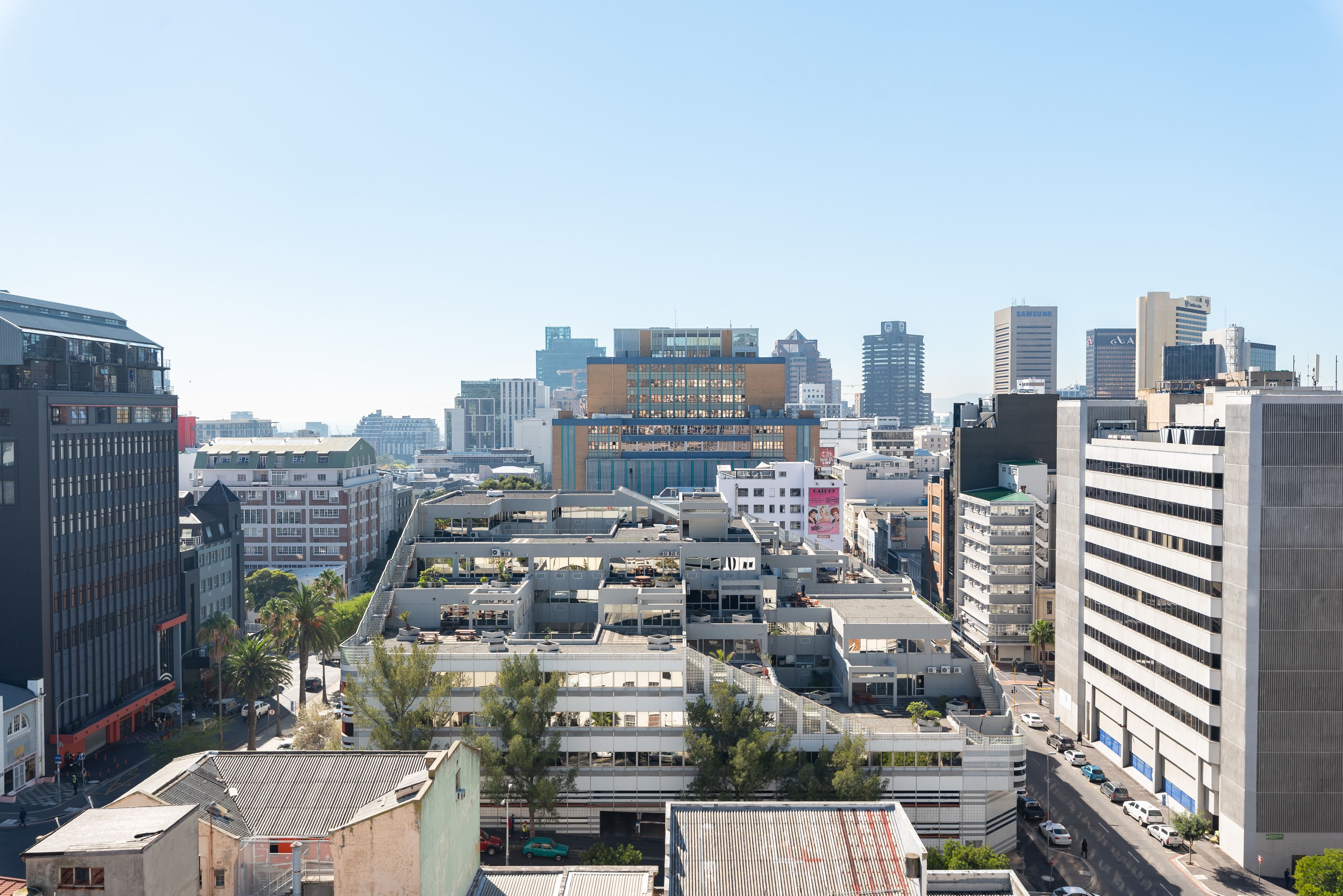 A cityscape with modern buildings, including a prominent building with a blue and orange facade.