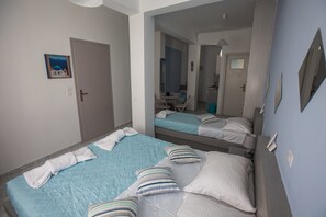 Una habitación de hotel con dos camas, baño y comedor.