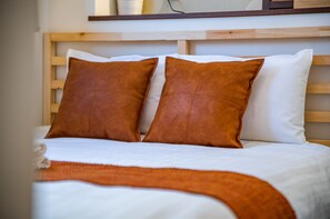 A neatly made bed with two brown pillows and a white blanket. - Kujira 203 (Osaka)