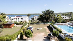 A residential area with a swimming pool, a small wooden cabin, and a view of the sea. - Hostal Port Fornells - Adults Only (Mercadal)