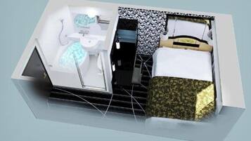 Una habitación de hotel compacta con cama, baño pequeño y zona de estar.
