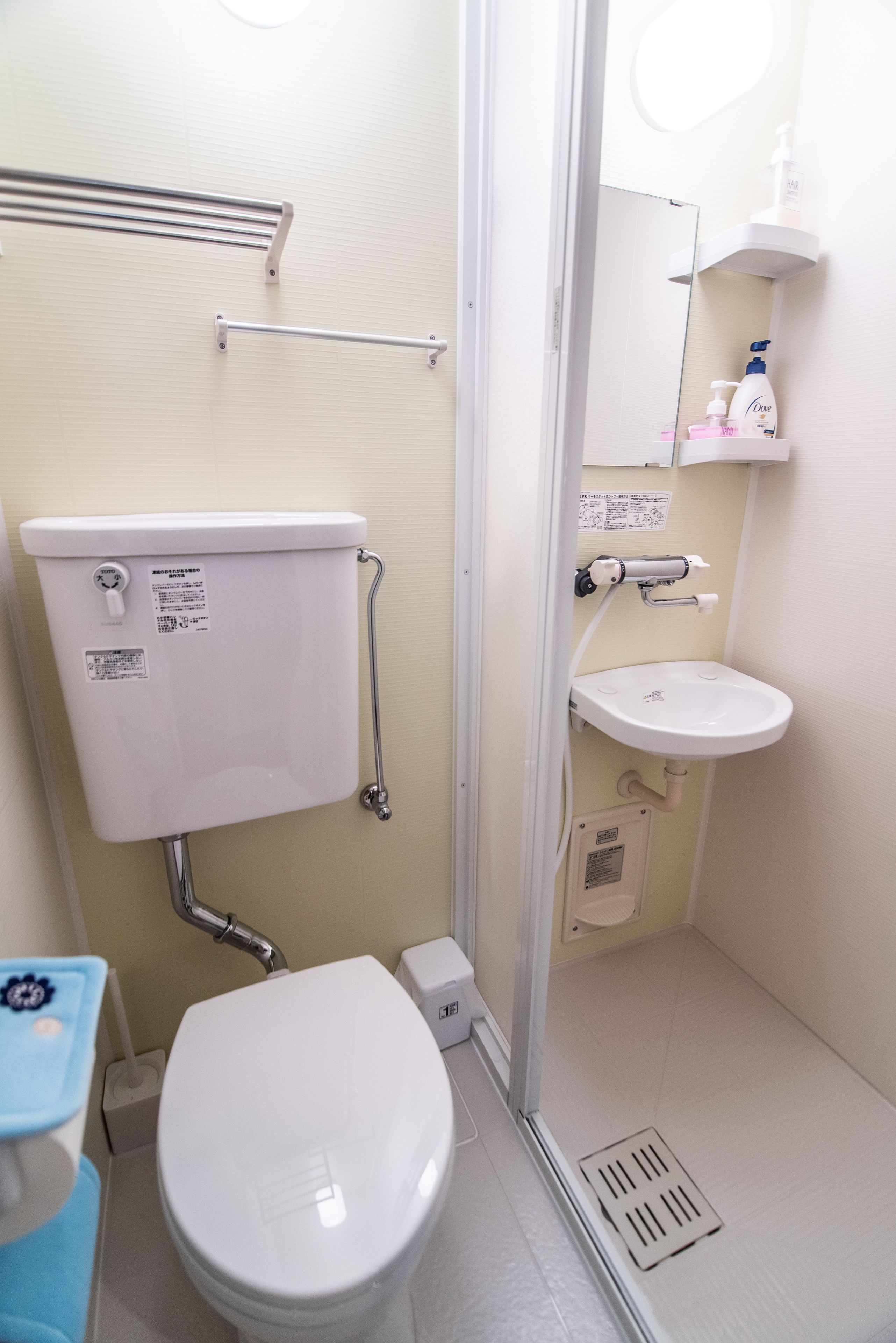 A small, compact bathroom with a white toilet, a sink, and a shower area.