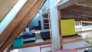 Ein Schlafsaalzimmer mit Etagenbetten, einem gelben Schrank und einem Fenster.