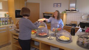 A buffet setup with covered dishes of various foods, a kitchen area with appliances, and a counter with beverages. - Landhotel Larenzen (Kirchham)