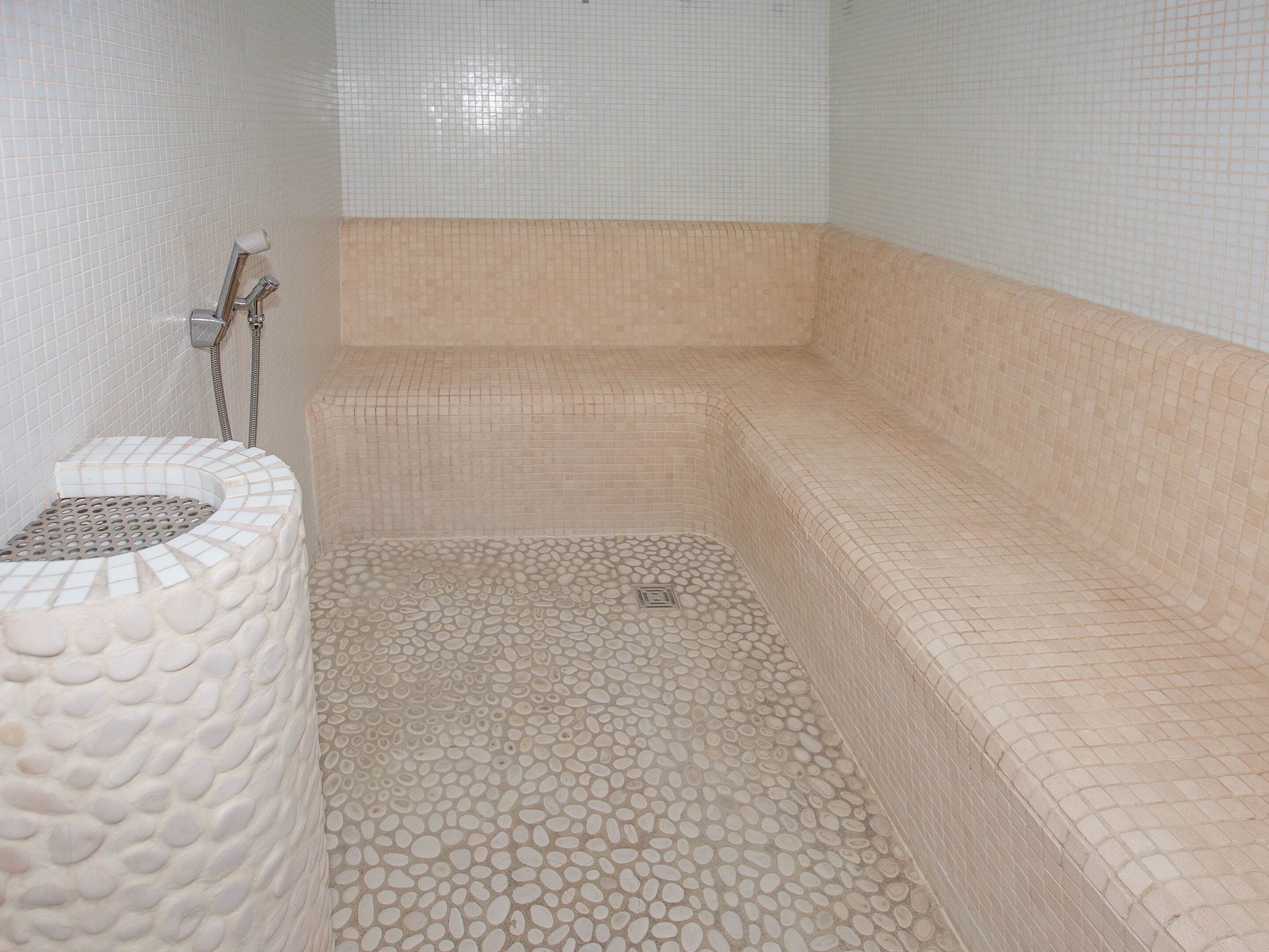 Un baño con bañera, ducha y suelo de baldosas.