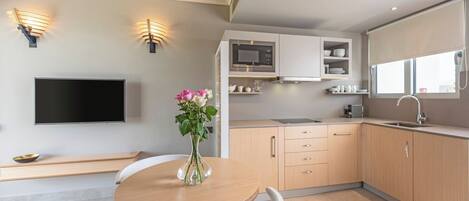 A modern kitchen with wooden cabinets, a built-in microwave, and a large window.