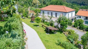 Ein Wohngebiet mit einem gepflasterten Weg, einer Bank und einem kleinen Park mit einem Brunnen.