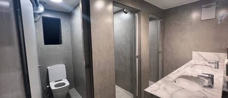 Ein modernes Badezimmer mit Toilette, Dusche und einem мрамор-Waschbecken.