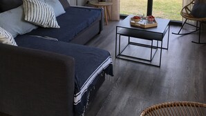 Una sala moderna con un sofá, una mesa de centro y una silla de mimbre.