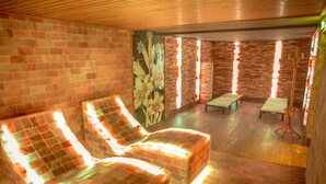 A spa room with two massage chairs, a small table, and a wall with vertical light strips. - Wellness Hotel Astra (Spindleruv Mlyn)