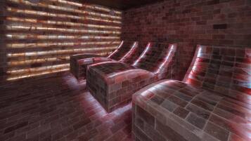 A spa room with a brick wall, a wooden ceiling, and a large window with blinds.