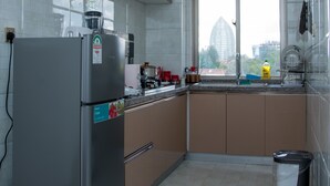A compact kitchen with a refrigerator, stove, and sink. - Spacious one bedroom apartment in Kileleshwa Nairobi (Nairobi)