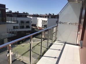 A modern building with a glass balcony overlooking a courtyard.