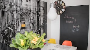 Una habitación con una pizarra que muestra 'Welcome home!' y una planta en maceta sobre una mesa.
