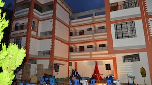 A multi-story building with a courtyard, outdoor seating, and a stage for events. - Snow Peak Hotel (Chogoria)
