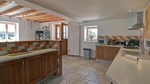 A modern kitchen with wooden cabinets, a tiled backsplash, and a central island.