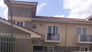 A residential building with a gated entrance, a balcony, and a tiled roof. - Muthama Heights (Syokimau)