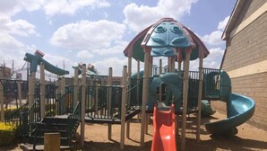 A playground with a slide and climbing structures. - Muthama Heights (Syokimau)