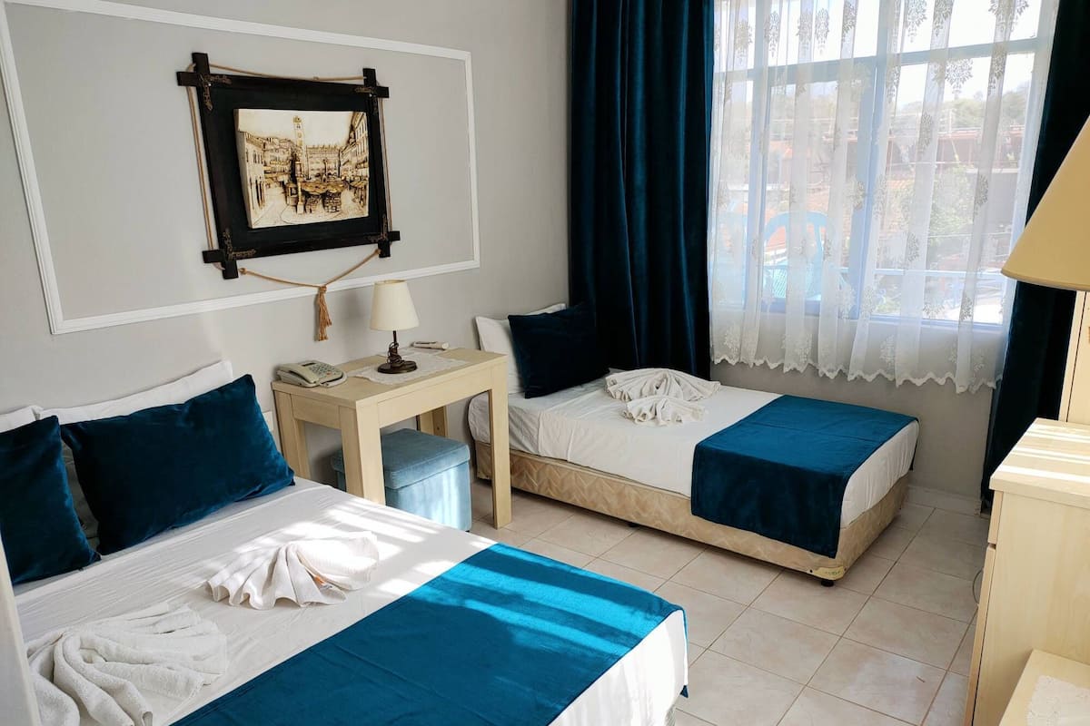 Standard Triple Room, Garden View | Peralatan tempat tidur premium, bar mini, meja