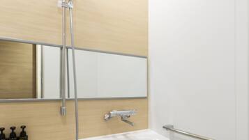 A modern bathroom with a white bathtub, a shower with a handheld showerhead, and a mirror above the sink.