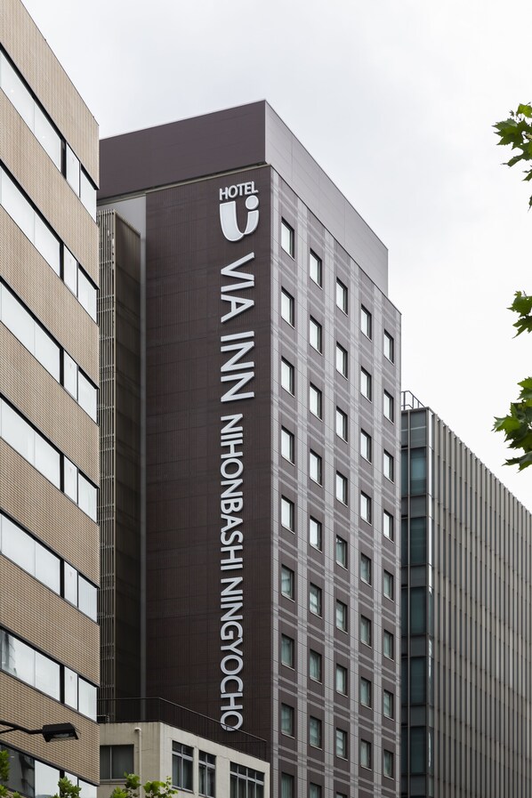 Ein modernes Hotelgebäude, dessen Fassade den Namen „HOTEL VIA INN NISHINBASHI NINGYOCHO“ deutlich zeigt.