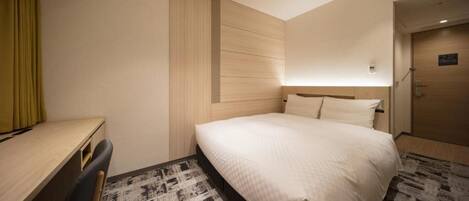Ein Hotelzimmer mit Bett, Schreibtisch und Stuhl.