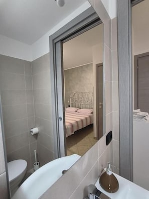 A bathroom with a bathtub, toilet, and a shower area.